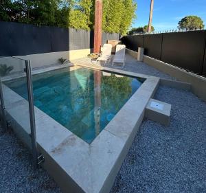 a swimming pool in a yard with two lounge chairs at La villa Bern in Sorgues