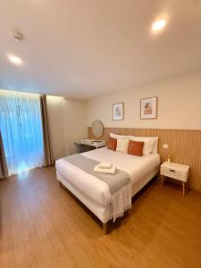 ein Schlafzimmer mit einem großen weißen Bett und einem Fenster in der Unterkunft Recanto do Cávado in Barcelinhos