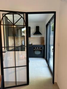a kitchen with a glass door leading into a room at La villa Bern in Sorgues