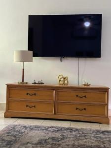 a wooden dresser with a flat screen tv on a wall at Gasakam in San Pedro Sula