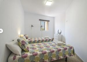 a bedroom with a bed with a comforter at Apartamento IFAE 3 in Guía de Isora