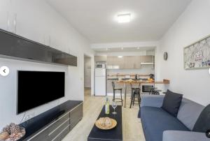 a living room with a blue couch and a flat screen tv at Apartamento IFAE 3 in Guía de Isora +13 photos