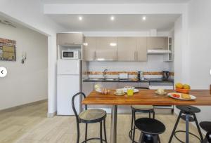 a kitchen with a wooden table and some chairs at Apartamento IFAE 3 in Guía de Isora