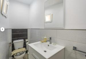 a bathroom with a white sink and a toilet at Apartamento IFAE 3 in Guía de Isora