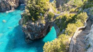 an island with an arch in the middle of the water at Hotel Blu Eden - Calabria oltre il mare in Praia a Mare