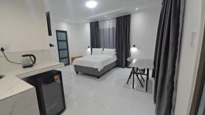 a hotel room with a bed and a desk at SADO Guesthouse in Katima Mulilo