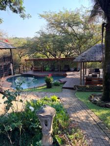 a backyard with a pool and a table and a pavilion at MTH in Nelspruit