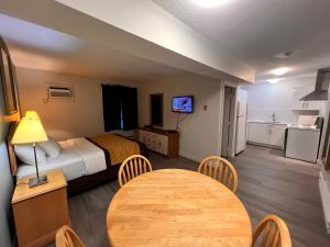 a hotel room with a bed and a table and a kitchen at Armstrong Inn in Armstrong