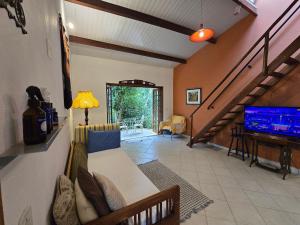 a living room with a couch and a flat screen tv at Casa Amarela, Refúgio na natureza Rota do vinho in São Roque