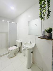 a white bathroom with a toilet and a sink at Hotel Marie Real Cartagena in Cartagena de Indias +141 photos