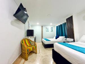 a hotel room with two beds and a flat screen tv at Hotel Marie Real Cartagena in Cartagena de Indias