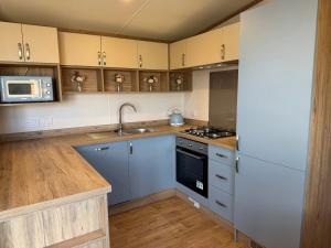 a kitchen with a sink and a stove at Luxury lodge Henley in Cherry Burton