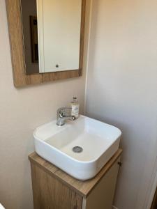 a white sink in a bathroom with a mirror at Luxury lodge Henley in Cherry Burton +9 photos