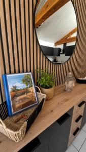 a table with a mirror and a picture on it at Gite de charme avec jaccuzzi privé in Coëx +4 photos