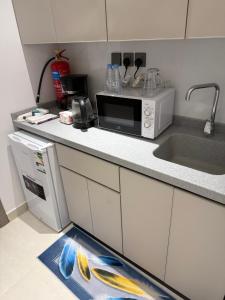a kitchen with a sink and a microwave at Levin in Al Majma'ah +6 photos