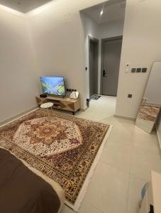 a living room with a rug and a laptop on a table at Levin in Al Majma'ah