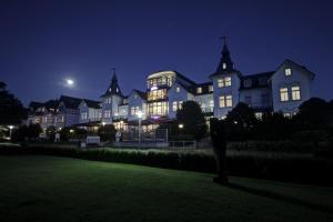 una casa grande por la noche con las luces encendidas en Hotel Asgard's Meereswarte, en Zinnowitz