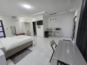 a bedroom with a bed and a table and a kitchen at SADO Guesthouse in Katima Mulilo