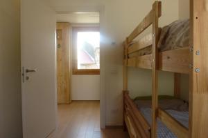 Volpago del MontelloにあるCasa Kaletheiaの二段ベッド2台と窓が備わる客室です。
