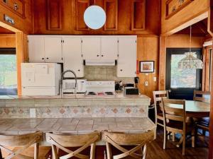 a kitchen with white cabinets and a table with chairs at Views inside Yosemite-Timber Lodge-Sleeps 6 in Yosemite West