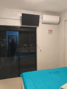 a room with a bed and a window with a fan at Excelente apartamento aconchegante in Taguatinga