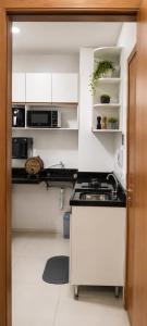 a small kitchen with white cabinets and a sink at Excelente apartamento aconchegante in Taguatinga +3 photos
