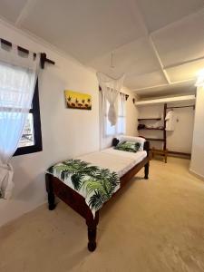 a bedroom with a bed and a window at Mepoho Beach Villa Watamu in Watamu