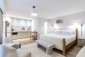 a white bedroom with a bed and a kitchen at Sand and Stone Resort in Huntsville