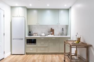 a kitchen with white cabinets and a white refrigerator at Sand and Stone Resort in Huntsville