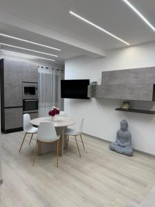 a dining room with a table and white chairs at XIII Tempio in Cisterna di Latina