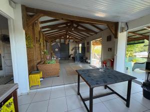 a room with a table and a living room at Maison créole avec piscine et accès à la rivière in Lamentin