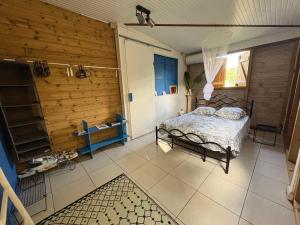 a bedroom with a bed and a wooden wall at Maison créole avec piscine et accès à la rivière in Lamentin +11 photos