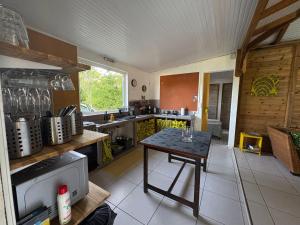 a kitchen with a table in the middle of it at Maison créole avec piscine et accès à la rivière in Lamentin
