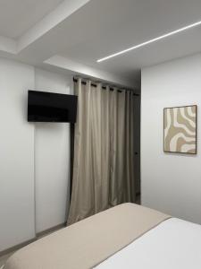 a bedroom with a bed and a television on a wall at XIII Tempio in Cisterna di Latina