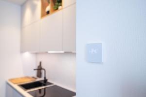 a kitchen with white cabinets and a sink at Luxorious Japandi design apartment in Otepää