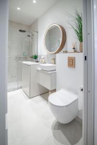 a bathroom with a toilet and a sink and a mirror at Luxorious Japandi design apartment in Otepää +26 photos