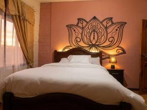 a bedroom with a large bed with a flower design on the wall at Casa Refugio del Amanecer en Baños de Agua Santa in Lligua