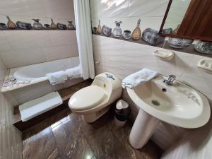 a bathroom with a sink and a toilet and a tub at Casa Refugio del Amanecer en Baños de Agua Santa in Lligua +34 photos