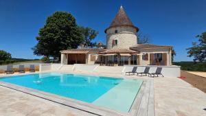 a villa with a swimming pool in front of a house at Colombier de Scandaillac in Saint-Eutrope-de-Born