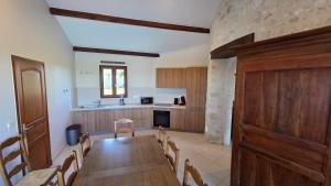a dining room with a table and a kitchen at Colombier de Scandaillac in Saint-Eutrope-de-Born