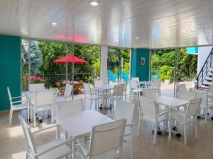 a dining room with white tables and white chairs at HOTEL NATIVOS in La Vega