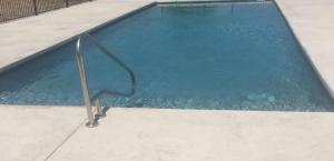 an empty swimming pool with a metal hand rail in it at Sagebrush Hotel in Crystal City