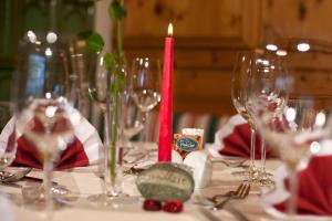 StuhlfeldenにあるHotel Flatscherのワイングラスと赤いキャンドルが置かれたテーブル
