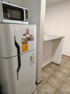 a white refrigerator with a microwave on top of it at Lihuel 1 AG in Alta Gracia