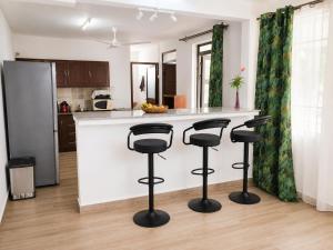 a kitchen with a counter and stools in a kitchen at Villa Saint Malo in Pereybere