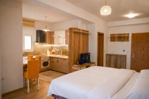 a bedroom with a white bed and a kitchen at Beach Walk Apartments in Ulcinj