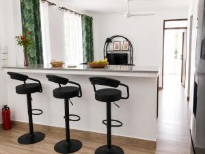 a kitchen with black bar stools at a counter at Villa Saint Malo in Pereybere