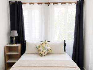 a bedroom with a bed with black curtains and a window at Villa Saint Malo in Pereybere