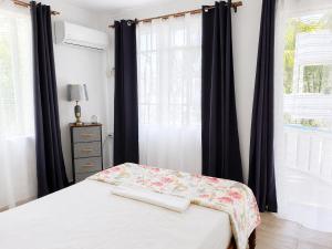 a bedroom with a bed with black curtains and a window at Villa Saint Malo in Pereybere