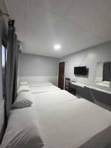 a hospital room with four beds and a tv at Hotel Cabana in Parauapebas
